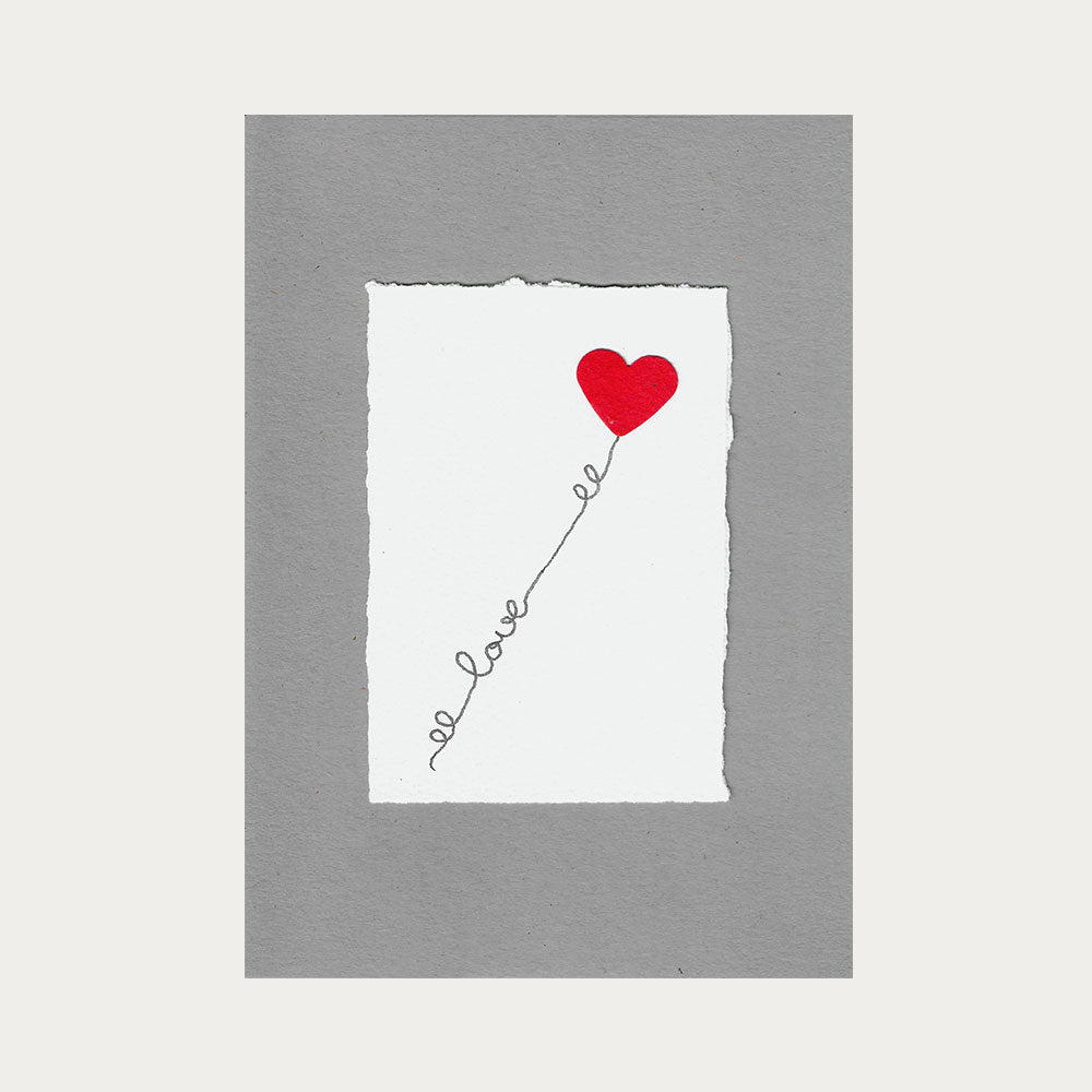 Graue Karte mit weissem Hintergrund, einem Roten Herz und dem Schriftzug 